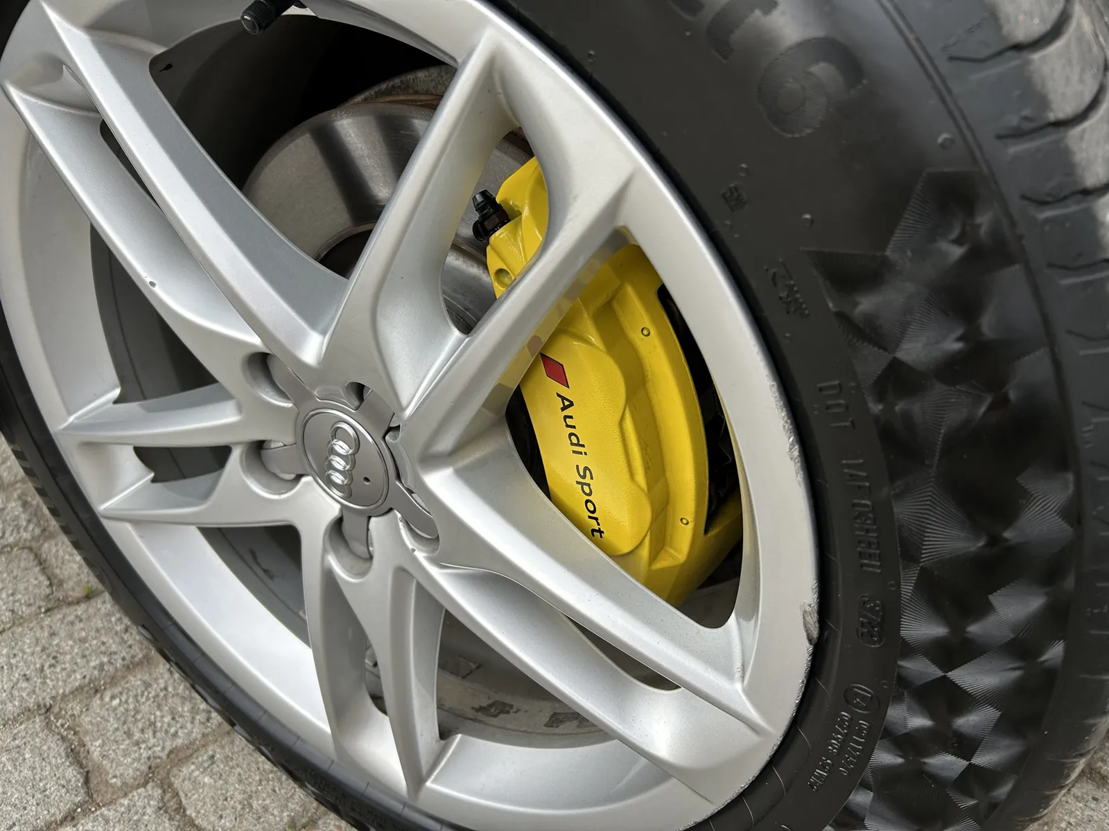 Żółty zacisk hamulcowy z napisem Audi Sport za felgą Audi Q5