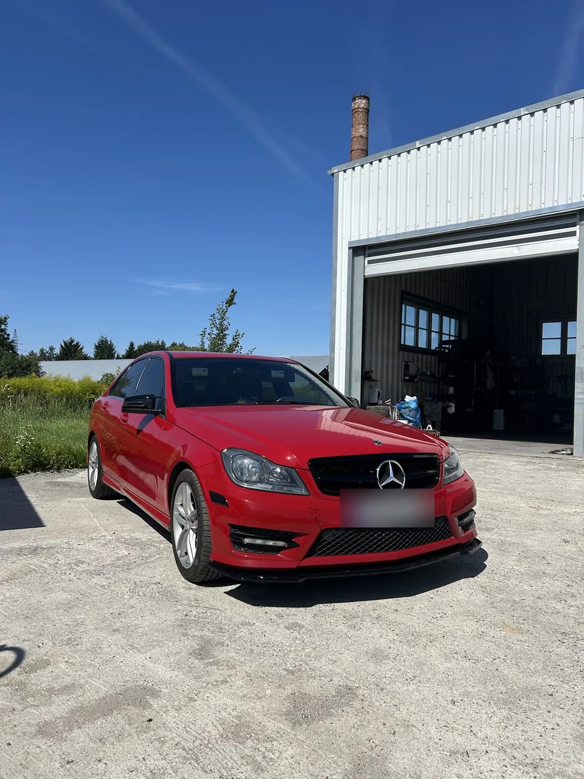 Czerwony Mercedes C250 W204 z czarną dokładką, grillem i lusterkami